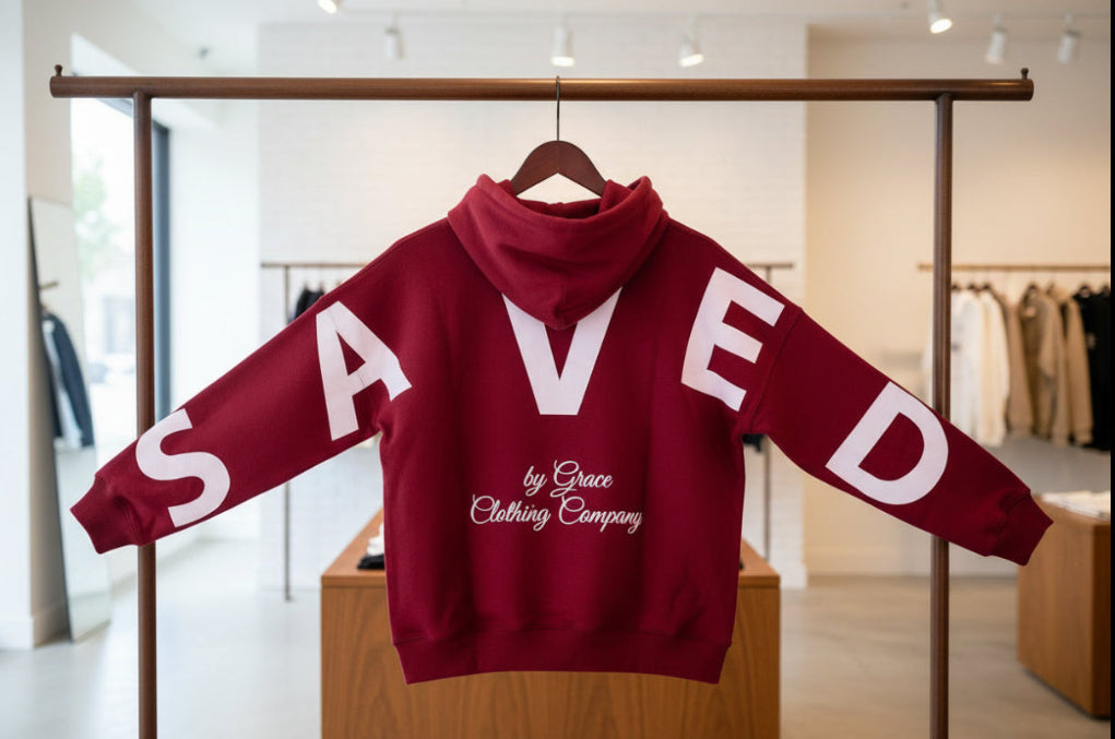 Red hoodie with 'SAVED by Grace Clothing Company' text on a white background